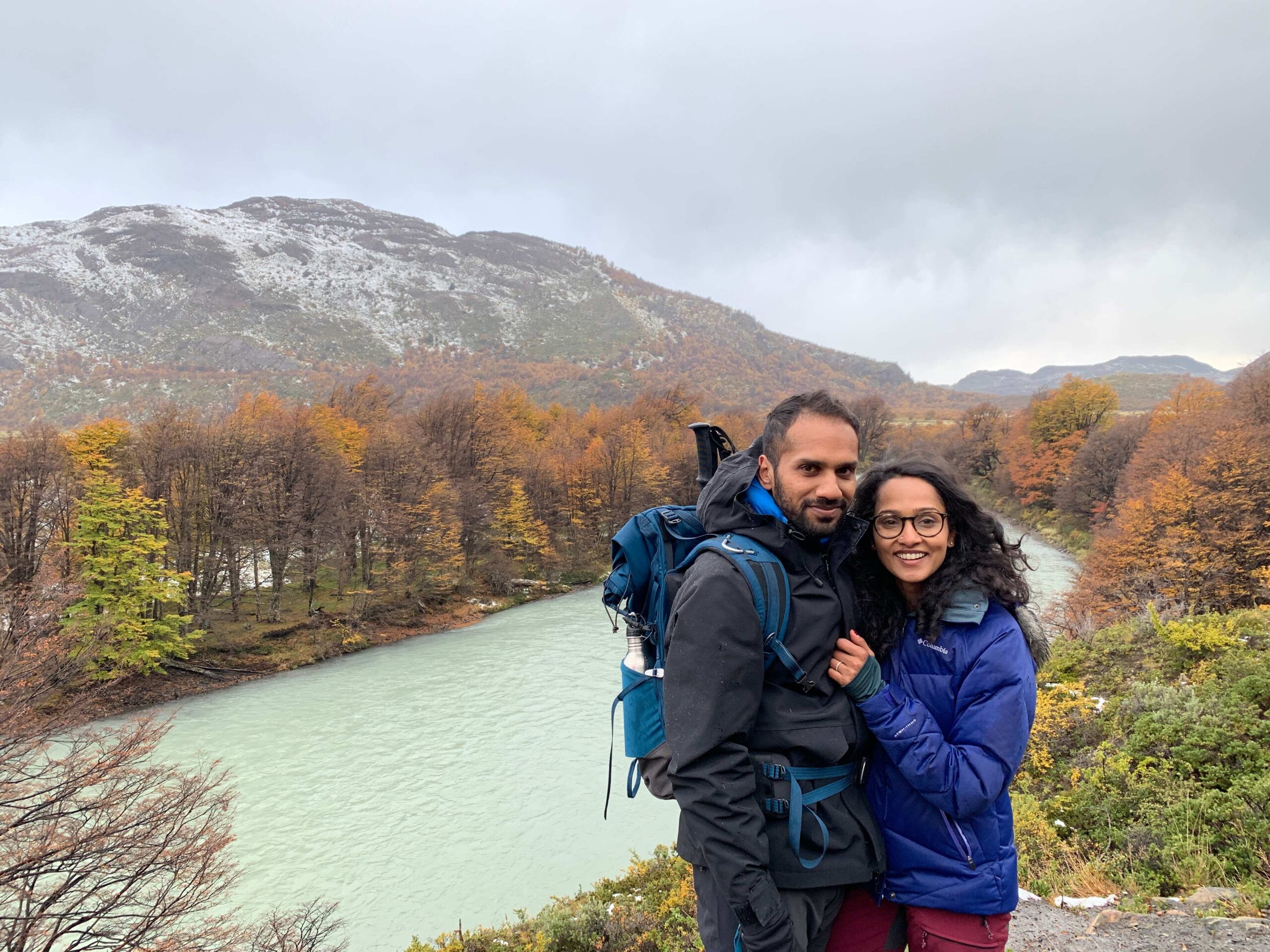 Namisha and Raghunath hiking near a river and mountain